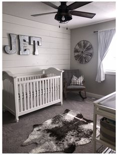 a baby's room is decorated in gray and white