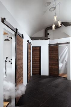 steam coming out of two doors in a room with white walls and black flooring