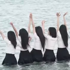 four girls in the water with their arms up