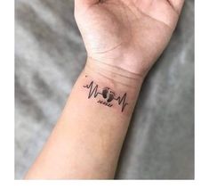 a person's wrist with a heartbeat tattoo on the left side of their arm