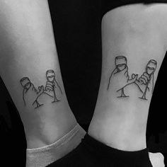 two people with matching tattoos on their legs, one is holding the other's hand