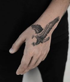 a person with a tattoo on their hand and an eagle tattooed on the left wrist