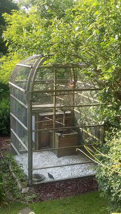 a bird cage in the middle of a garden