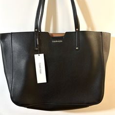 Calvin Klein Bag In Black With Tan Inside. Has A Logo Zip Up Pocket With 2 Slip In Pockets Inside Bag. Snaps Shut. 100% Man Made Material. About 19” Across Top, 15” Across Bottom, 12 1/2” Tall Not Including Straps. Calvin Klein Tote Bag, Calvin Klein Fragrance, Calvin Klein Bags, Calvin Klein Bag, Inside Bag, Oversized Tote, Nylon Tote Bags, Brown Tote, Gold Handbags