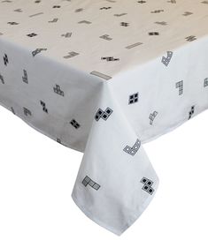 a white table cloth with black squares and crosses on it, in front of a white background