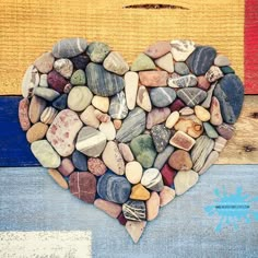 a heart made out of rocks sitting on top of a blue and white striped wall