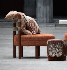 an orange chair and footstool sitting in front of a table with a bird on it