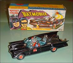 a toy batman car next to a box on a table