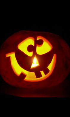 a pumpkin carved to look like a jack - o'- lantern in the dark