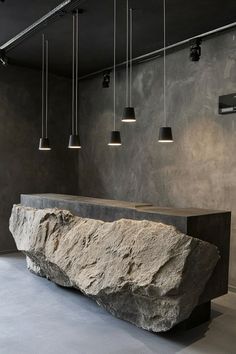 a large rock sitting in the middle of a room with lights hanging from it's ceiling