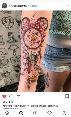 a person with a tattoo on their arm that has an image of mickey mouse and other things