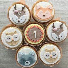 cupcakes with frosting decorated like animals and numbers are arranged in a circle