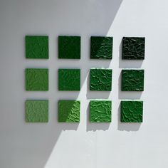 green squares are arranged on a white wall