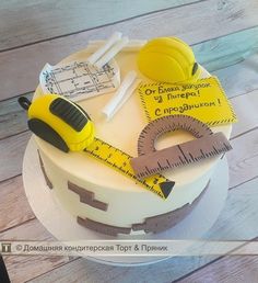 there is a cake that has been decorated with construction tools and tape measure on it