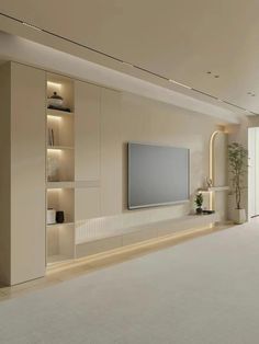 an empty living room with a large flat screen tv on the wall and shelves in front of it