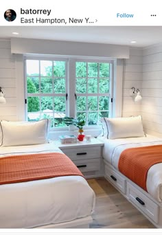 two beds in a room with white walls and wood floors