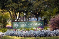 there is a sign that says the college of william and mary in front of some flowers