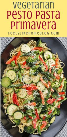 a black plate topped with pasta and veggies