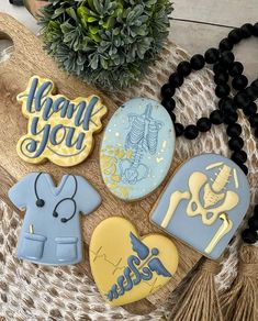 decorated cookies with the words thank you in blue, yellow and white on a table