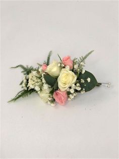 a bouquet of white and pink flowers with greenery on the side, against a white background