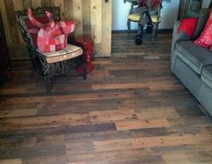 a living room filled with furniture and lots of red pillows on top of it's wooden floor