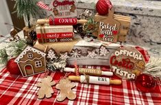 gingerbread cookies are displayed on a red and white checkered tablecloth with christmas decorations