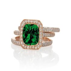 a green ring set with diamonds on the sides and an emerald stone in the middle