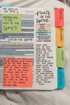 an open bible with colorful sticky notes on the pages and words written in different languages