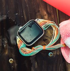 an open cell phone sitting on top of a wooden table next to a pink hat