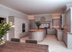 a large kitchen with an island and wooden table