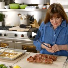 a woman cutting up food on top of a kitchen counter