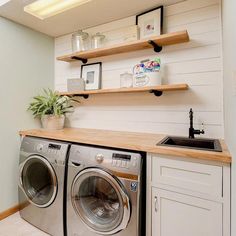 a washer and dryer in a small room with open shelving on the wall