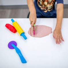 a young child is playing with toys on the table