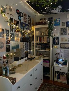 a room filled with lots of clutter and pictures on the wall next to a desk