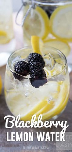 blackberry lemon water in a glass with ice and blackberries on the rim, surrounded by sliced lemons