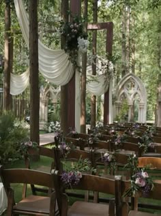 an outdoor wedding setup with wooden chairs and flowers