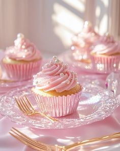 cupcakes with pink frosting and sprinkles on plates