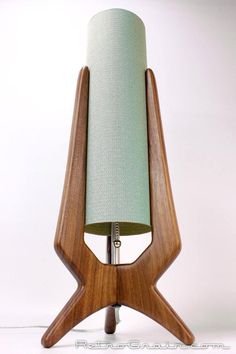 a wooden table lamp with a green shade on it's side and a white background