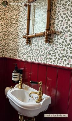 a white sink sitting under a bathroom mirror next to a wall mounted faucet