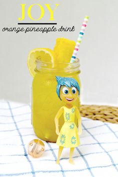 an orange pineapple drink with a doll next to it