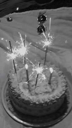 a cake with sparklers on it sitting on a table