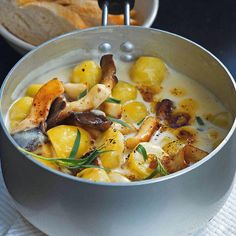 a bowl filled with soup and bread on top of a table next to another bowl