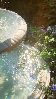 a water feature in the middle of some flowers