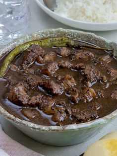 a bowl filled with meat and rice on top of a table