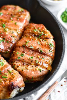 pork chops in a skillet with herbs and seasoning on the side, ready to be eaten