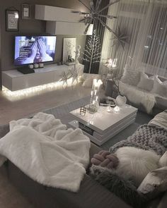 a living room filled with lots of furniture and a flat screen tv mounted on the wall