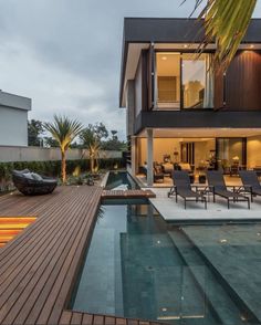 a house with a swimming pool and lounge chairs