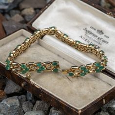 This lovely bracelet is accented with forty-eight (48), prong set, marquise mixed cut natural emeralds and thirty-two (32), channel set, round brilliant cut diamonds. The bracelet measures 7.2mm wide, 4.0mm thick and an overall length of 7 inches. The bracelet is finished with a hidden box clasp. Emerald Tennis Bracelet With 17 Jewels For Wedding, Marquise Emerald Jewelry For Formal Occasions, Formal Marquise Emerald Jewelry, Emerald Gemstone Tennis Bracelet For Anniversary, Green Emerald Bracelet, Thirty Two, Emerald Bracelet, Box Clasp, Channel Set