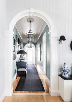 an archway leading to a living room with blue walls and white trim on the ceiling