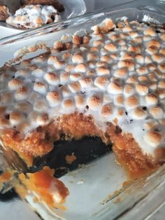 a dessert dish with marshmallows and icing on it in a glass pan